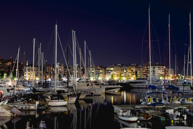 Paesaggio marino notturno con yacht barche e motoscafi sul molo in estate Atene Grecia