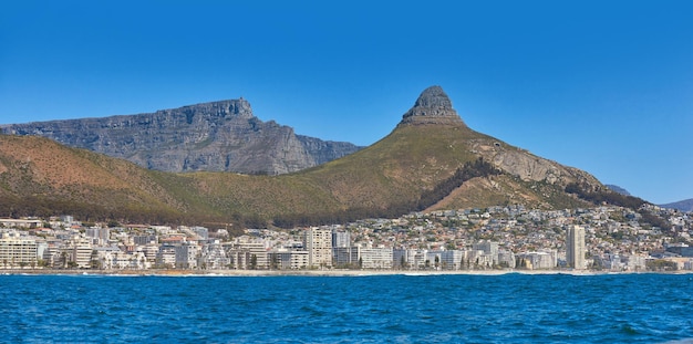 Paesaggio marino panoramico con cielo azzurro e copia spazio e moderni condomini sullo sfondo Sea Point con vista su Lions Head e Table Mountain National Park Città del Capo Sud Africa