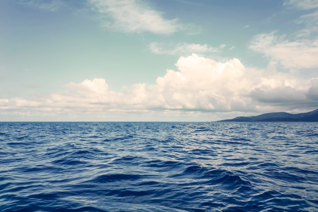 Paesaggio marino Superficie dell'acqua Cielo nuvoloso e montagne