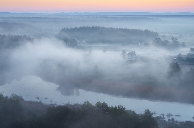 Paesaggio mattutino con nebbia sul fiume