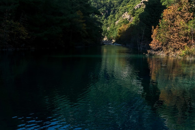 Paesaggio montano autunnale con limpido lago ombroso