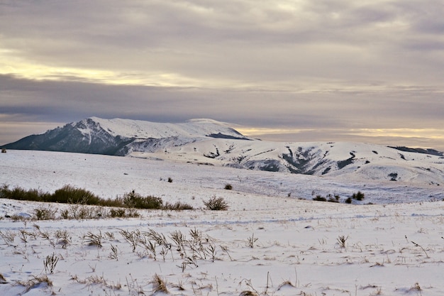 Paesaggio montano, cielo grigio e nuvole di neve