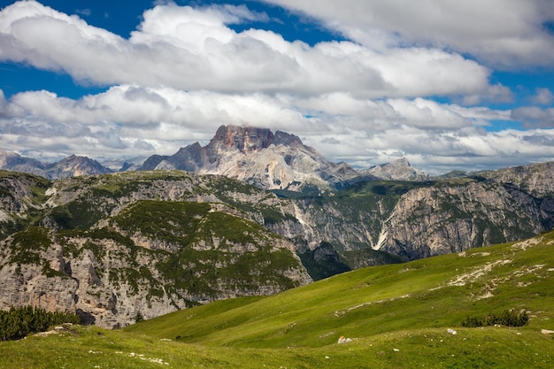 Paesaggio montano soleggiato con grandi cime delle Dolomiti con cielo blu e vallata d'erba Alpi del Passo di Giau Italia Europa