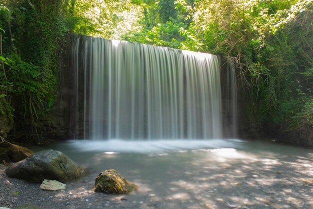 Paesaggio naturale idilliaco con piccola cascata nel bosco Italia