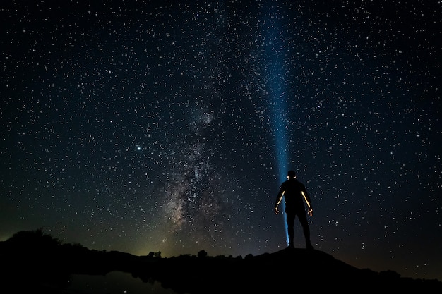 Paesaggio notturno stellato con sagoma umana