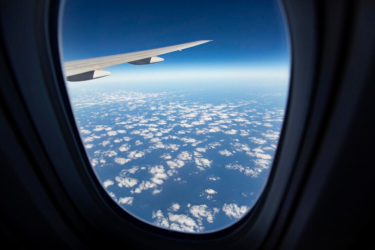 Foto paesaggio nuvoloso contro il cielo blu attraverso la finestra dell'aereo
