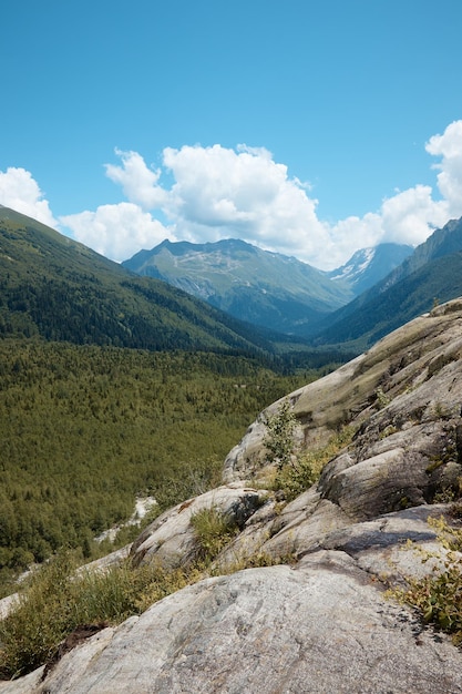 Paesaggio, panorama montano, prati alpini e picchi di montagna nel ghiaccio, una piccola casa sul fianco della montagna