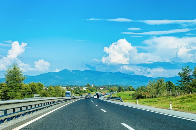 Paesaggio panoramico con auto su strada in Slovenia. Sullo sfondo le Alpi Giulie.