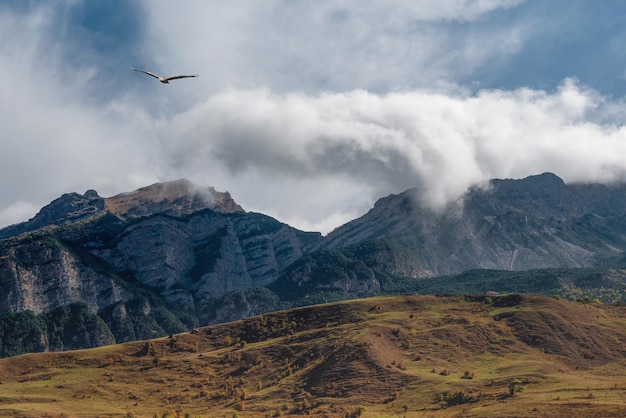 Paesaggio panoramico con valle di montagna autunnale contro il grande monte