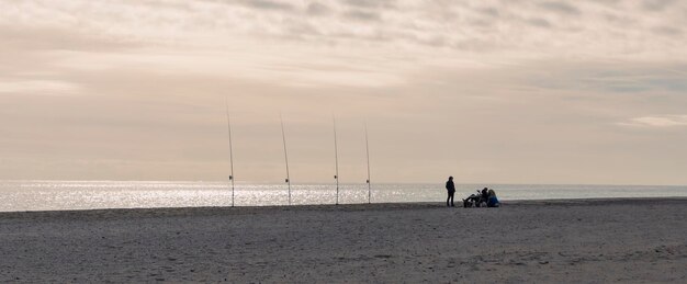 Paesaggio panoramico. Sagoma di pescatore, palme, monte sulle rive del mar mediterraneo