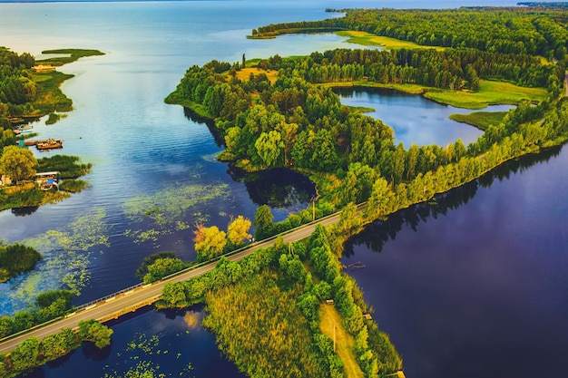 Paesaggio rurale al tramonto estivo con lago e strada, sfondo naturale, vista aerea