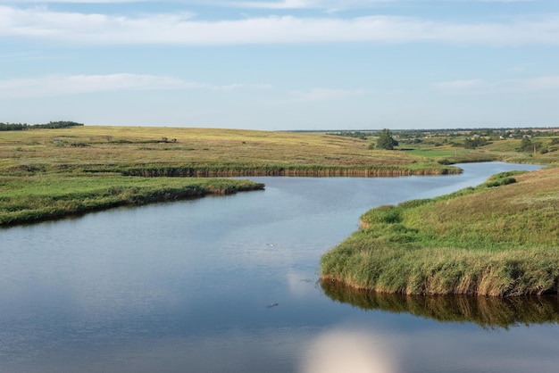 Paesaggio rurale di un campo con un fiume sullo sfondo di un cielo nuvoloso agosto ucraina