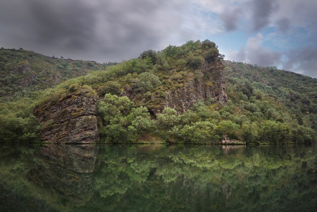 Paesaggio scenico delle riflessioni e rovine in un lago tranquillo un giorno nuvoloso, La Rioja, Spagna.