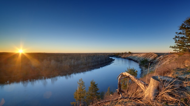 Paesaggio serale con fiume, al tramonto