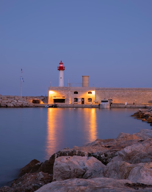 paesaggio serale e un faro splendente sul mare