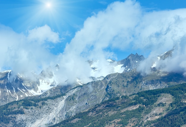 Paesaggio soleggiato di montagna estiva con neve sulla cima del monte (Alpi, Svizzera)