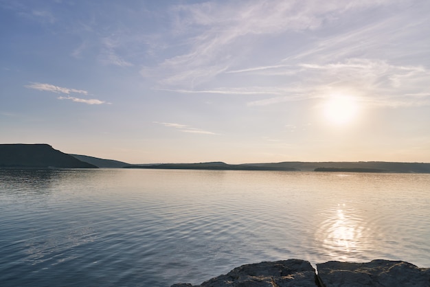 Paesaggio su acqua e costa rocciosa.