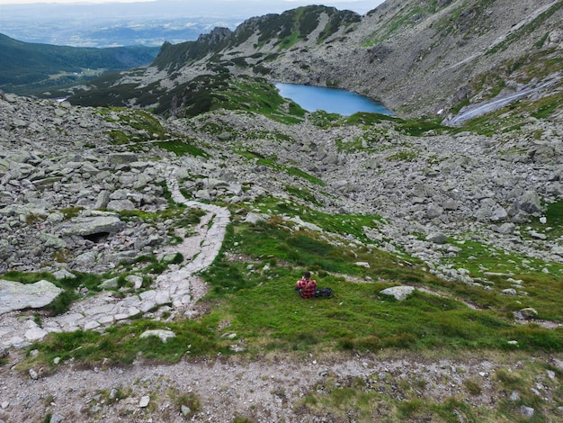 Paesaggio sui monti Tatra in Polonia Czarny Staw Gasienicowa un uomo siede su una collina