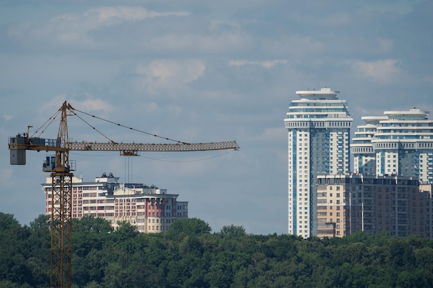 paesaggio urbano con grattacieli, gru edili e torre della TV