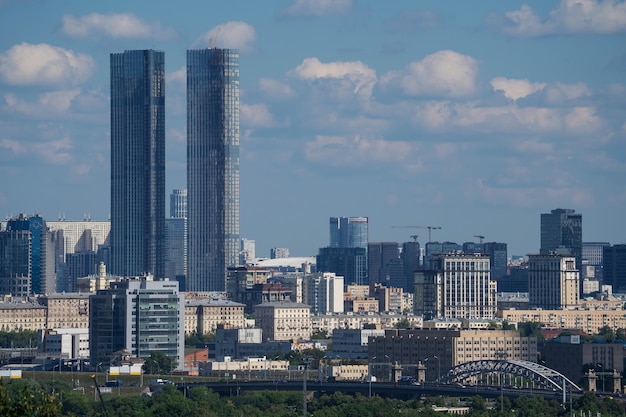 paesaggio urbano con grattacieli, gru edili e torre della TV