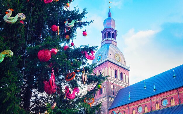 Paesaggio urbano con mercatino di Natale in piazza Duomo a Riga d'inverno, Lettonia. Decorazione della Fiera dell'Avvento e bancarelle con oggetti di artigianato sul Bazaar. Natale e vacanze in strada lettone