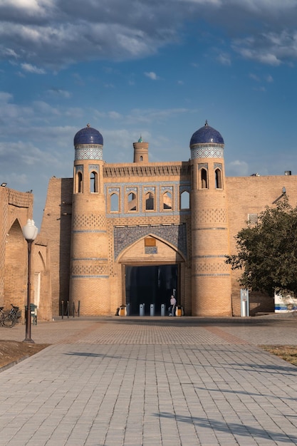 Paesaggio urbano con porte Polvon darvoza alla città vecchia di IchanKala contro il cielo nuvoloso Khiva Uzbekistan