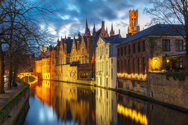 Paesaggio urbano con una torre Belfort e il canale verde a Bruges a