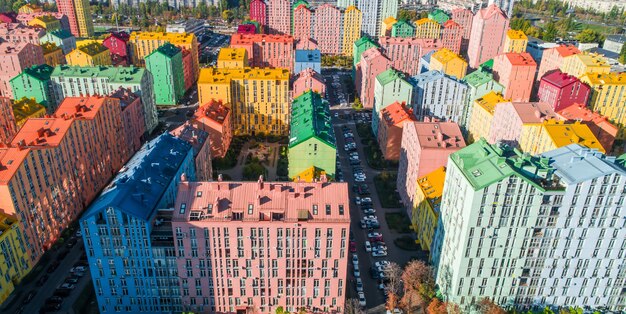 Paesaggio urbano di edifici colorati. Vista aerea degli edifici colorati della città europea alla luce del sole del mattino. Paesaggio urbano con case multicolori, automobili per strada a Kiev, Ucraina