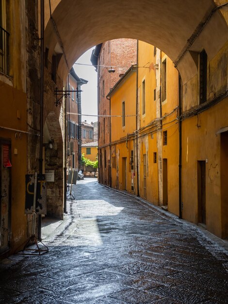 Paesaggio urbano di una città antica Pisa con vecchi edifici, una stradina, un arco e lastricati