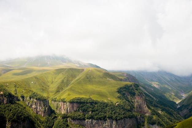 Paesaggio verde della valle della collina della montagna. Le montagne si avvicinano alla città Stepantsminda, Kazbegi, Georgia.