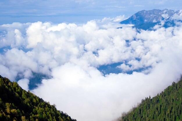 Paesaggio - vista dalla cima della montagna in una giornata di sole alla valle nascosta da nuvole basse