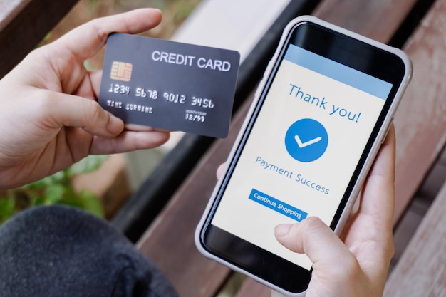 Pagamento mobile mani donna che tiene la carta di credito e utilizza lo smartphone per il pagamento online
