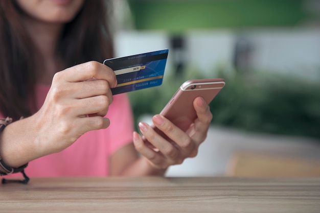 Pagamento online di compera con la carta di credito, donna che per mezzo dello smartphone mobile, commercio elettronico di affari e concetto dell'applicazione