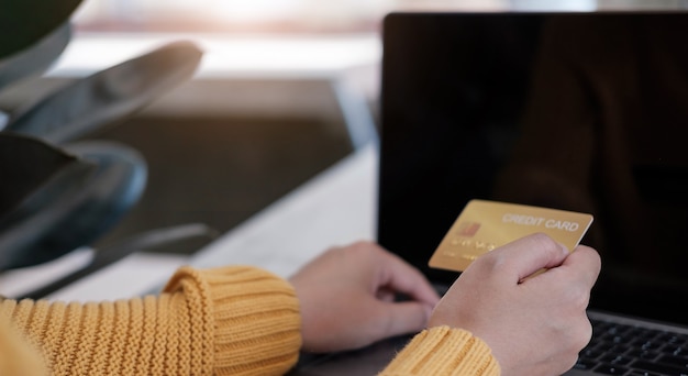 Pagamento online, le mani del giovane utilizzando il computer e la carta di credito in mano per lo shopping online