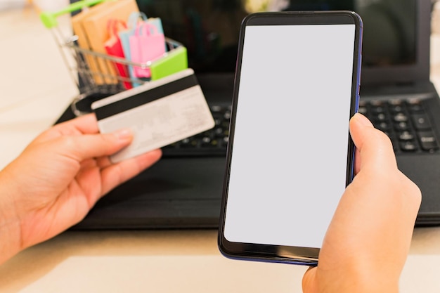 Pagamento online mani della donna con smartphone e utilizzo della carta di credito per lo shopping online