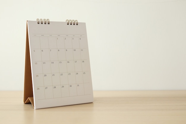 Pagina del calendario si chiuda sulla tavola di legno con il concetto di riunione appuntamento appuntamento di pianificazione aziendale sfondo muro bianco