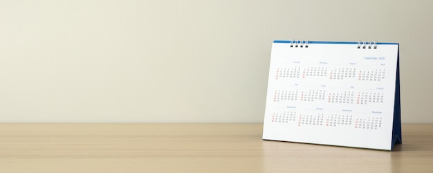 Pagina del calendario si chiuda sulla tavola di legno con il concetto di riunione appuntamento appuntamento di pianificazione aziendale sfondo muro bianco