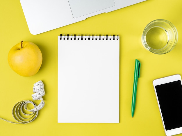 Pagina del taccuino in bianco per il programma o il menu di dieta, misura di nastro, concetto di perdita di peso