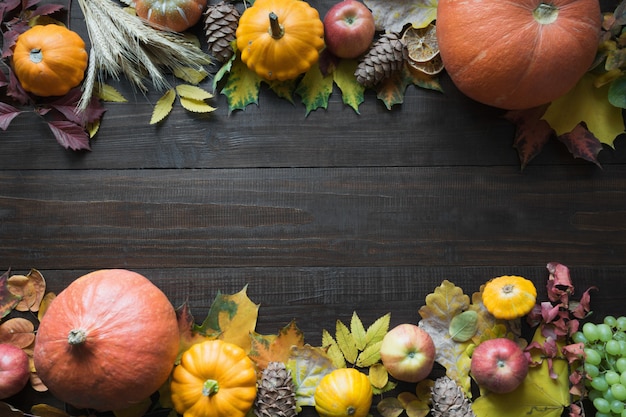 Pagina della zucca e delle foglie di acero sul bordo di legno con la vista superiore del modello di caduta