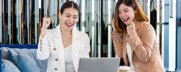 Pagina web banner o modello di copertina di due donne d'affari asiatiche che celebrano la felicità