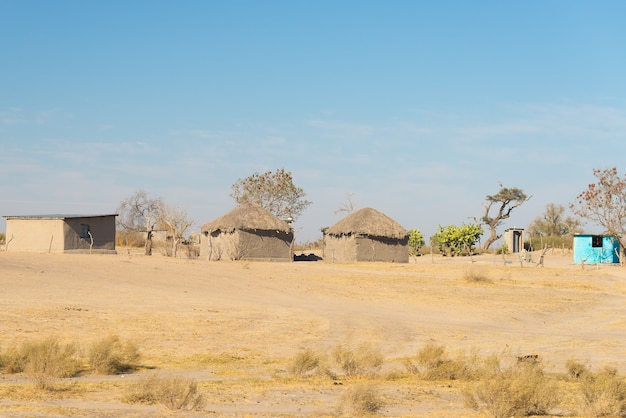 Paglia di fango e capanna di legno con tetto di paglia nella boscaglia. Namibia, Africa.