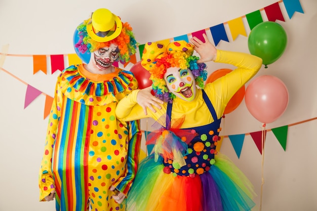 Pagliaccio allegro e un clown spaventoso a una festa colorata