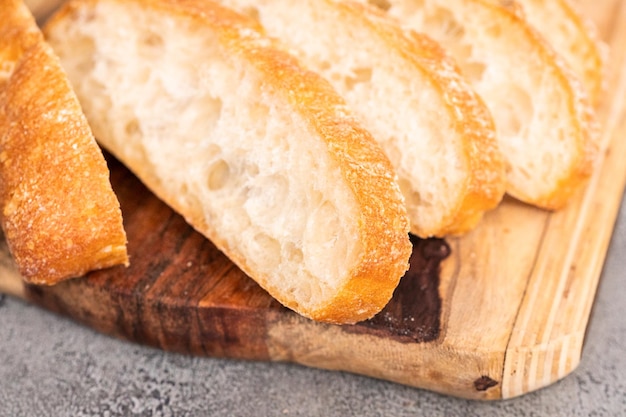 Pagnotta affettata di pane ciabatta appena sfornato sul tavolo grigio.