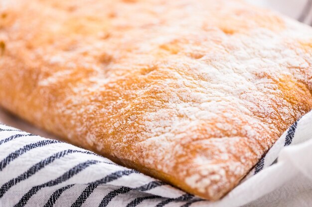 Pagnotta di ciabatta appena sfornata sul tavolo grigio.