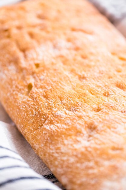 Pagnotta di ciabatta appena sfornata sul tavolo grigio.