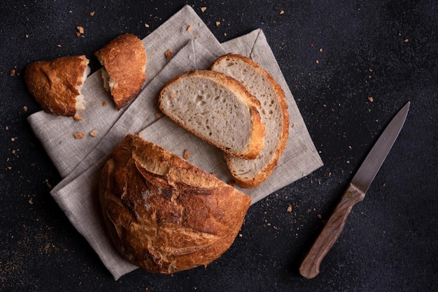 Pagnotta di pane appena sfornata e tagliata su sfondo scuro