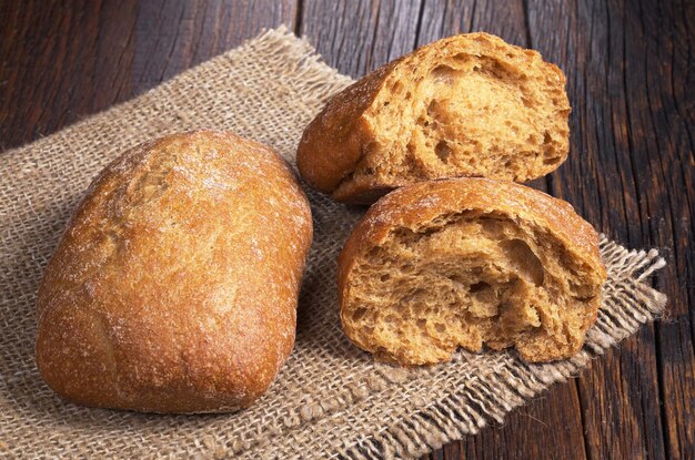 Pagnotta di pane ciabatta e due metà su tavola di legno rustica