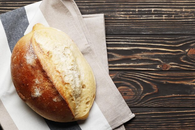 Pagnotta di pane fatto in casa con accessori da cucina e ingredienti da forno su un tavolo di legno con posto per il testo. Panetteria fresca.