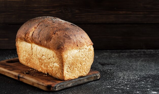 Pagnotta di primo piano bianco pane rustico su una tavola di legno dopo la cottura