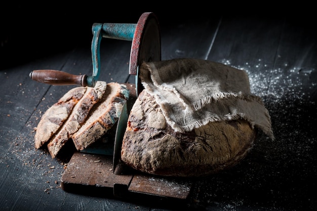 Pagnotta fatta in casa sull'affettatrice con briciole e farina